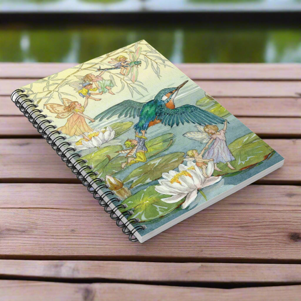 Notebook with a colorful design of fairies and a bird on a white background