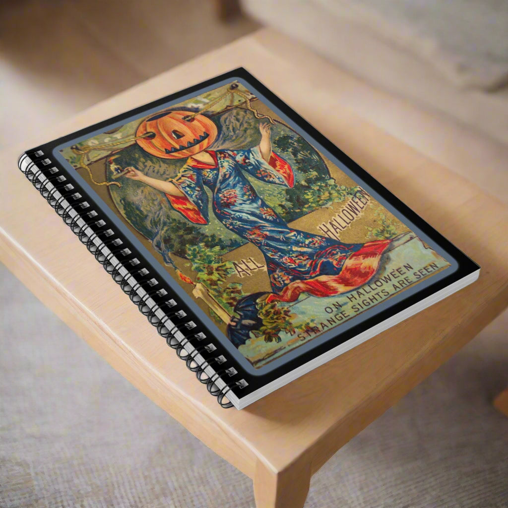 Notebook with a Halloween-themed cover featuring a person with a pumpkin head and a blue dress.