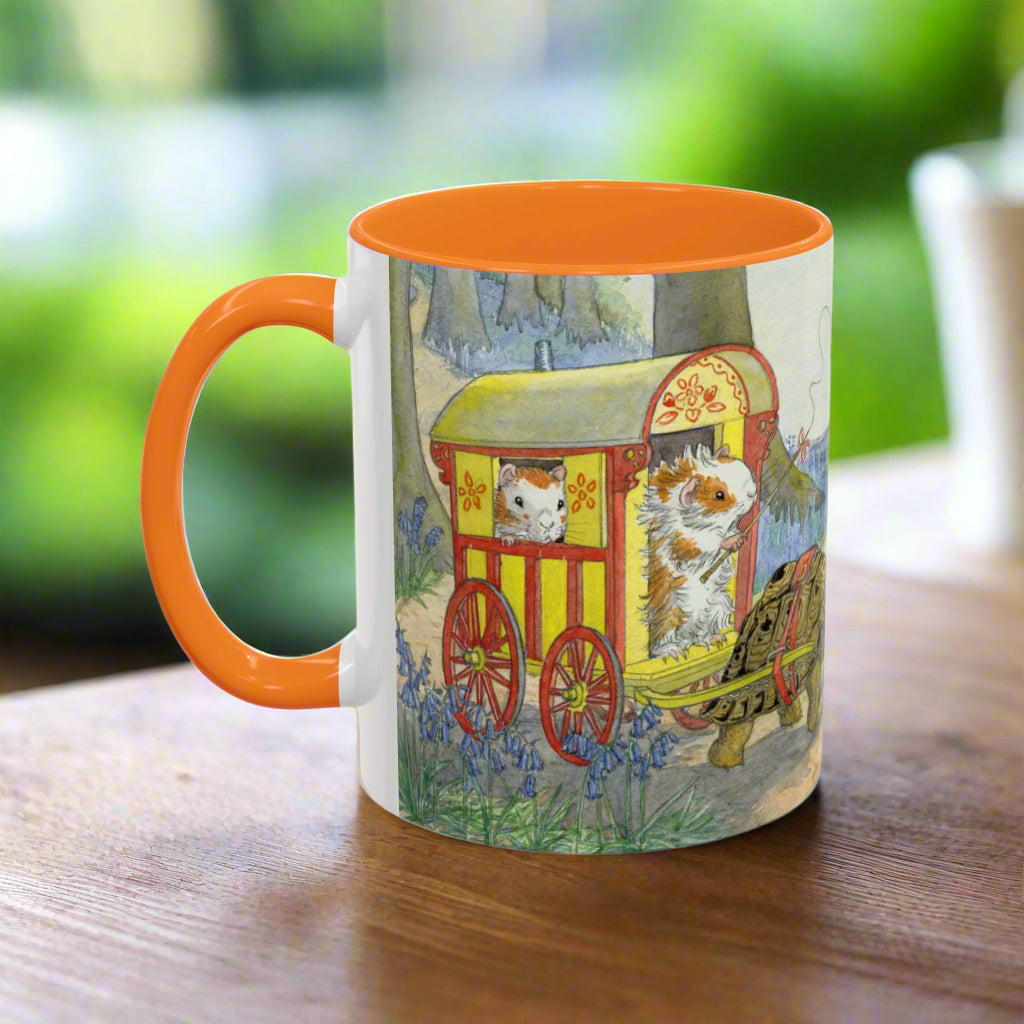 Mug with orange handle and colorful design of a caravan of guinea pigs and with woodland animals from a children's story book