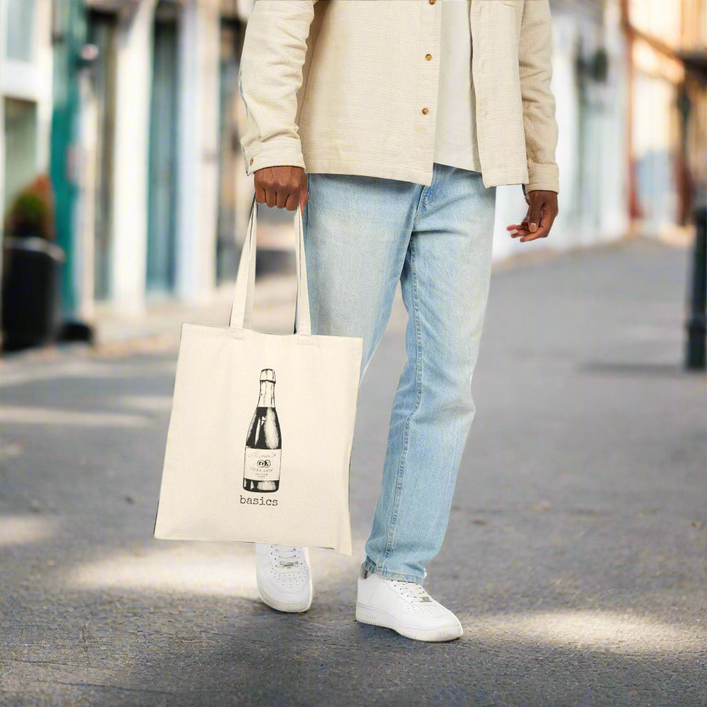 Person holding a tote bag with a bottle design on a white background